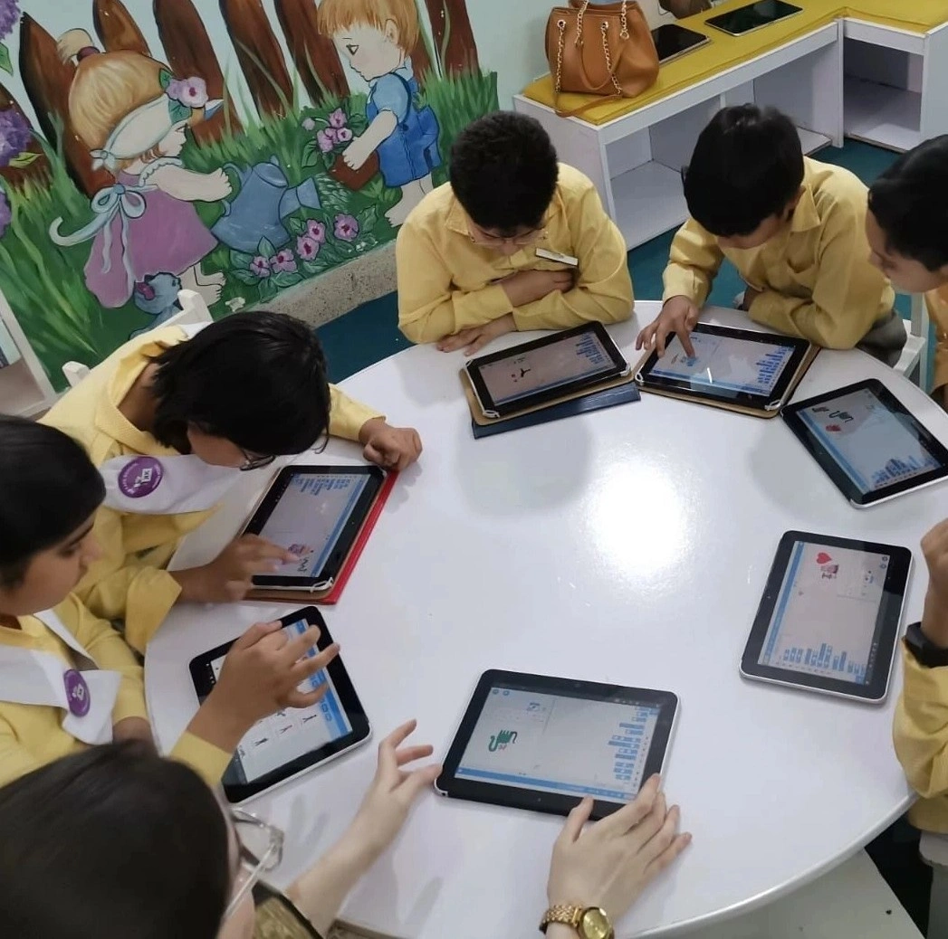 A child smiling while using a laptop